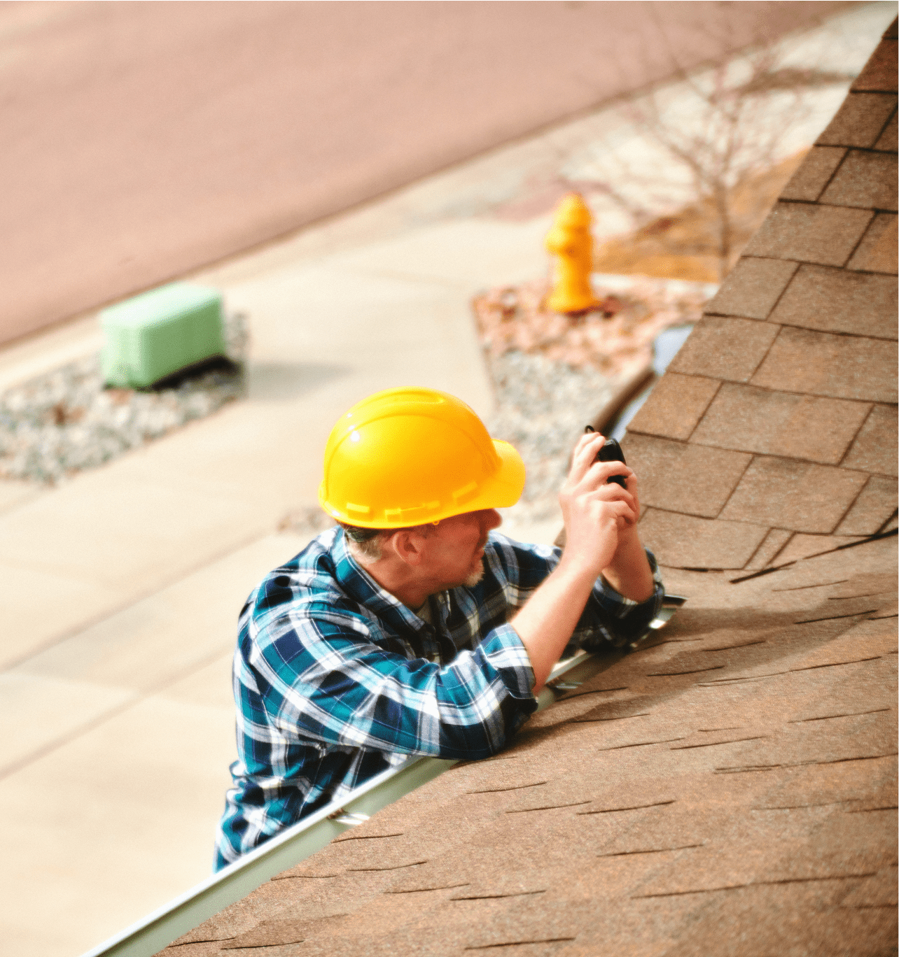Worker inspecting roof in hard hat